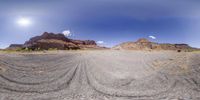 a view from the road shows mountains with dirt in it and the blue sky above them