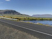 this is an image of a road with water and grass on both sides of the road