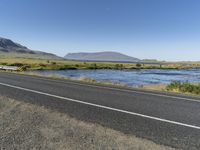 this is an image of a road with water and grass on both sides of the road