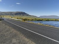 this is an image of a road with water and grass on both sides of the road