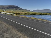 this is an image of a road with water and grass on both sides of the road