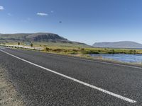 this is an image of a road with water and grass on both sides of the road