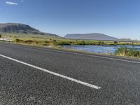 this is an image of a road with water and grass on both sides of the road