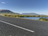 this is an image of a road with water and grass on both sides of the road