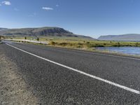 this is an image of a road with water and grass on both sides of the road