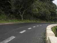 a road with a sign indicating the right turn ahead in a rural area surrounded by wooded hills