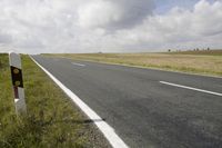 the road is empty and some white markings are seen on the side of it,