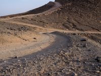 a truck on a dirt road in the desert with rocks and stones on the ground