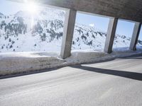 a long snowy highway with lots of snow on the side of it and snow capped mountains in the distance
