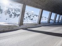 a long snowy highway with lots of snow on the side of it and snow capped mountains in the distance