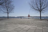 a street with trees and a boat ramp on the side of it near the water