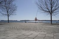 a street with trees and a boat ramp on the side of it near the water