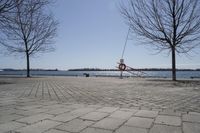 a street with trees and a boat ramp on the side of it near the water