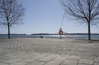 a street with trees and a boat ramp on the side of it near the water