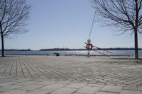 a street with trees and a boat ramp on the side of it near the water