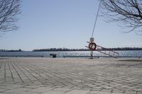 a street with trees and a boat ramp on the side of it near the water