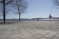 a street with trees and a boat ramp on the side of it near the water