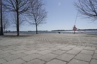 a street with trees and a boat ramp on the side of it near the water