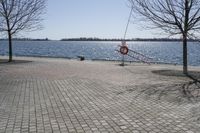 a street with trees and a boat ramp on the side of it near the water