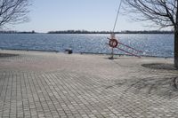 a street with trees and a boat ramp on the side of it near the water