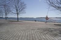 a street with trees and a boat ramp on the side of it near the water