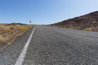 a lone country road with mountains in the background in southwest nevada near las crucet