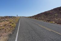 a lone country road with mountains in the background in southwest nevada near las crucet