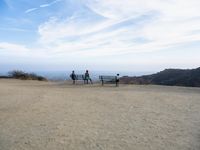 there are two people riding horses in the dirt area of a field in the mountain