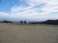 there are two people riding horses in the dirt area of a field in the mountain