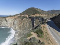 a view of the ocean as a train travels over the bridge over a cliffside