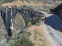 a view of the ocean as a train travels over the bridge over a cliffside