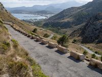 three cement barricades are placed on the road and along the side of the mountains