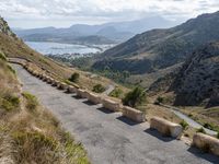 three cement barricades are placed on the road and along the side of the mountains