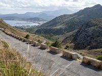 three cement barricades are placed on the road and along the side of the mountains