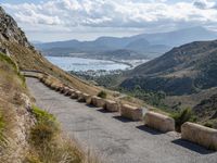 three cement barricades are placed on the road and along the side of the mountains