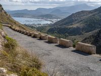 three cement barricades are placed on the road and along the side of the mountains