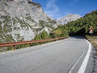 a long narrow highway with mountains behind it and the road below the curves on it