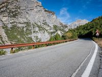 a long narrow highway with mountains behind it and the road below the curves on it