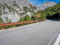 a long narrow highway with mountains behind it and the road below the curves on it