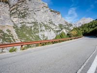 a long narrow highway with mountains behind it and the road below the curves on it