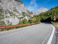 a long narrow highway with mountains behind it and the road below the curves on it