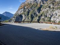 a wooden bench by a roadway with a mountain in the background in the mountains near gatli