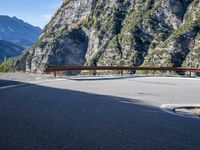 a wooden bench by a roadway with a mountain in the background in the mountains near gatli