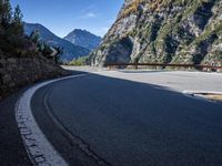 a wooden bench by a roadway with a mountain in the background in the mountains near gatli