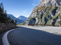 a wooden bench by a roadway with a mountain in the background in the mountains near gatli