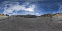 a view from the inside of a fisheye camera lens that shows a mountain road