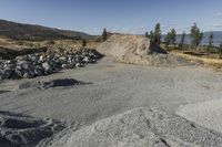 there is a bike rider on a paved dirt road through rocky area near a mountain