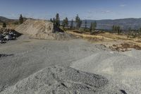 there is a bike rider on a paved dirt road through rocky area near a mountain