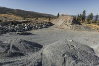 there is a bike rider on a paved dirt road through rocky area near a mountain