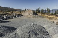 there is a bike rider on a paved dirt road through rocky area near a mountain